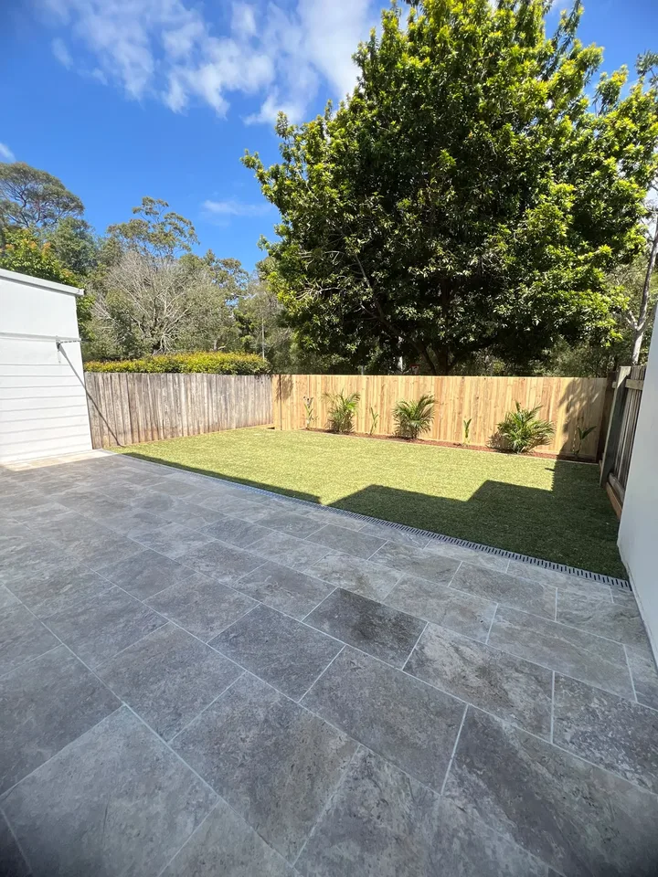 After the Buderim courtyard renovation: finished paved patio, lawn and new timber fence with planting